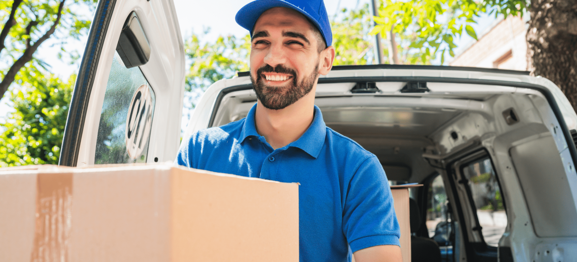 Delivery person loading packages into van.