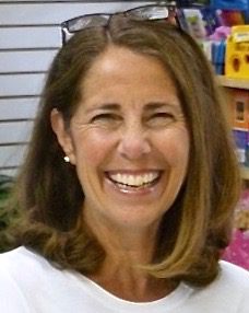 Smiling woman wearing glasses on her head.